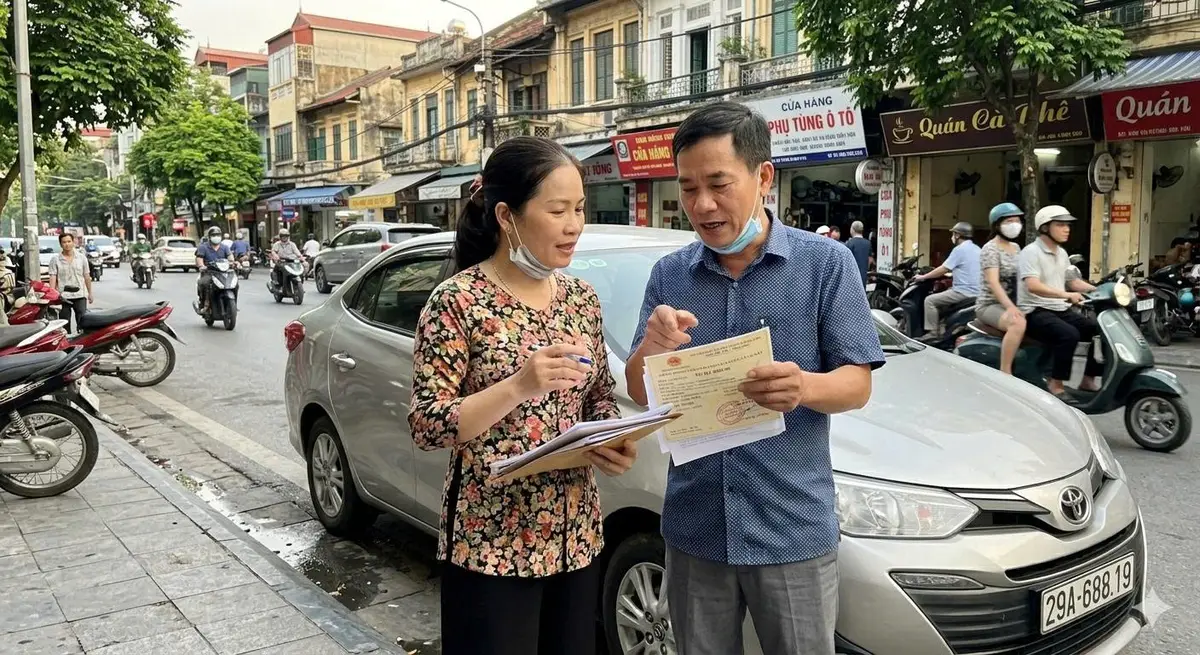 vợ chồng kiểm tra giấy tờ xe ô tô